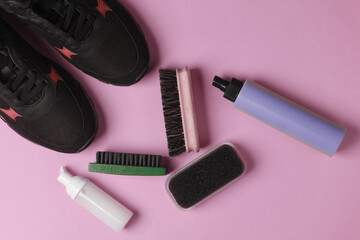 Sneakers with Shoe care products and accessories on pink background. Flat lay