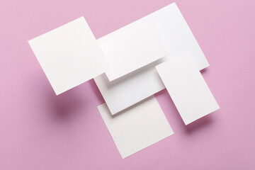 Composition of floating white square memo paper and cards on pink background. Mockup. Business concept