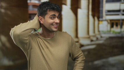 Man rubs head in scratch pose outdoor sporting hispanic young features with an unsure look as a guy displays a sheepish gesture.