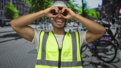 Man wearing hardhat and safety vest using hand binoculars on bustling city street; exploration...