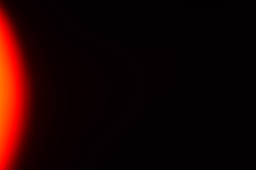 Vibrant orange-to-yellow gradient light leak streaming from left edge with intense luminous color saturation and smooth color progression fading into darkness. Authentic film photography effect showca