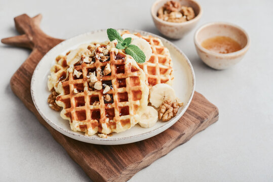 Homemade waffles with topping of honey, walnut and banana
