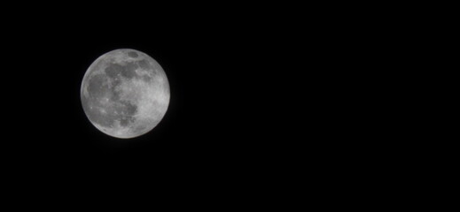 Photograph of an full moon in a dark sky. Image taken with a mobile phone lens with maximum zoom. Luminous moon with ethereal glow against pitch black sky. Supermoon, Night sky images
