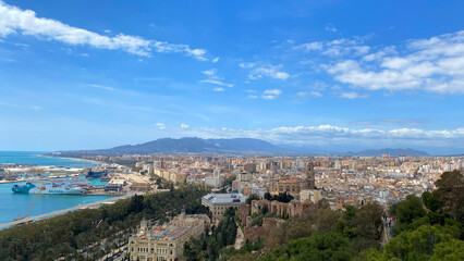 Malaga, Italy - July 12, 2022: Panoramic view of Barcelona coastline featuring cityscape, mountains, and vibrant blue sky with copy space