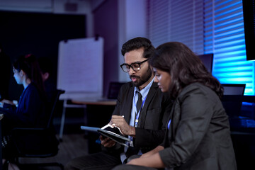 In a future marketing hub, a strategist uses a tablet to fine-tune a generative AI, creating a hyper-personalized ad campaign in real-time based on predictive analytics.