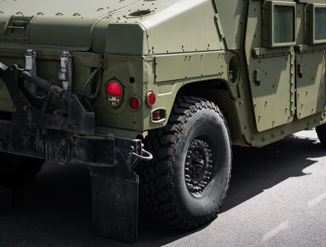 Close-up rear quarter view of a military Humvee truck. Olive drab green HMMWV with additional armor, large off-road tires and heavy-duty black bumpers, mud flaps. Ukraine - May 11 2025