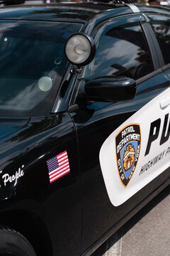 black Dodge Charger police car. Front left A-pillar of police cruiser with search light. Highway patrol cruiser with spotlight lamp. NY, USA - May 25 2025