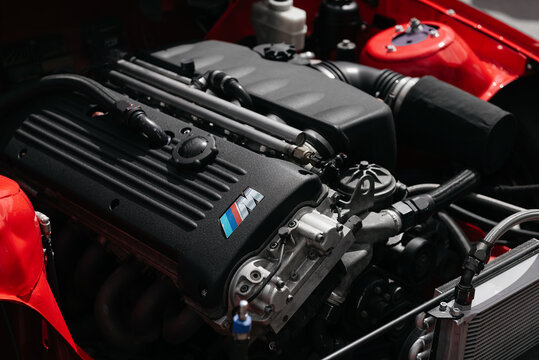 S54 engine in engine bay of red car. Under the bonnet of race car with naturally aspirated inline six motor. Kyiv, Ukraine - May 10 2025