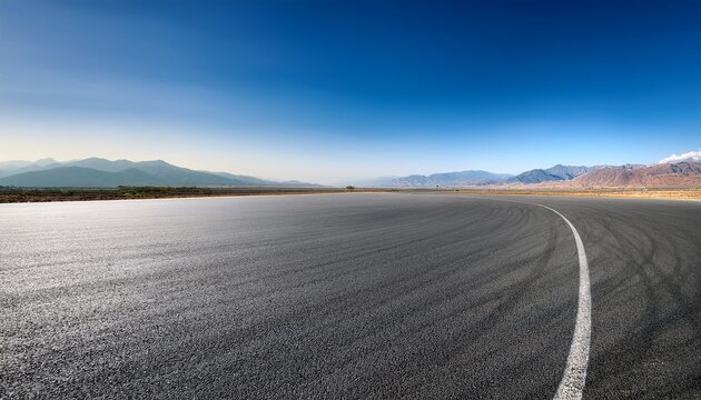vast deserted raceway under a clear blue sky with an expansive horizon featuring empty asphalt track stretching into the distance against distant mountains