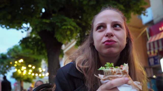 Girl enjoys tasty falafel wrap from street vendor in Sofia Bulgaria UGC 