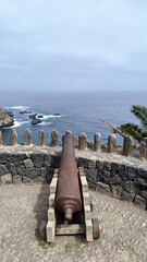 Old iron cannon facing the Atlantic Ocean atop the walls of historic San Fernando Fort, Rambla de Castro, Tenerife, Canary Islands, Spain.
