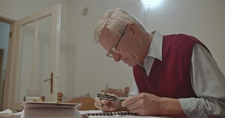 Elderly man intensely focused on his studies at home, meticulously reading with a magnifying glass and taking notes. This scene depicts lifelong learning, dedication, and concentration in retirement.