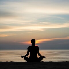 Fototapeta premium A silhouette of a person meditating in lotus pose on a beach at