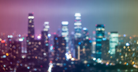 Glowing city lights scatter into bokeh circles that fill the skyline with blue, pink, and amber hues, capturing the atmosphere of a bustling metropolis at night.