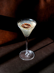 Margarita cocktail with orange slice on a brown table