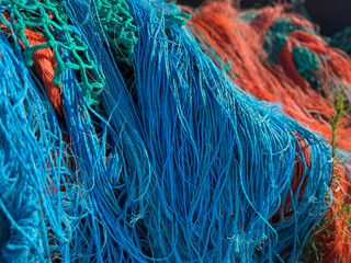 Multicolored orange blue fishing nets in the port