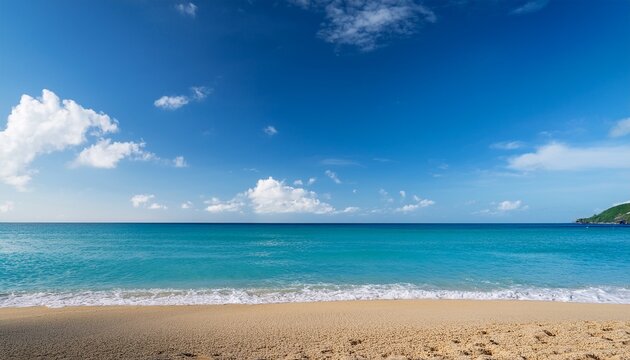 sunny day at the beach with a clear blue sky and a few white clouds