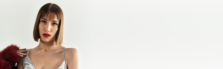 Fashionable young woman exudes confidence in stunning attire against a minimalist backdrop