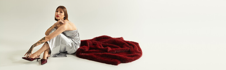 Fashionable young woman exudes confidence while posing with striking style on a simple background