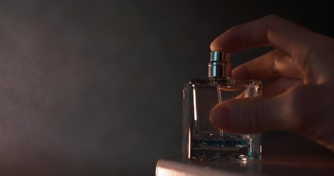 Male hand presses on the perfume and it makes a sound
