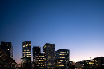 Architecture cityscape depicting Barcode Oslo skyline with building windows and glass illuminated at dusk shaping an expansive urban view for visual storytelling.