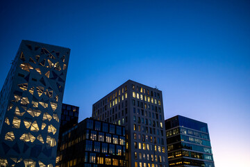 Architecture cityscape of Barcode Oslo forming a modern skyline where building glass lights and dusk shape an urban scene with contemporary appeal.