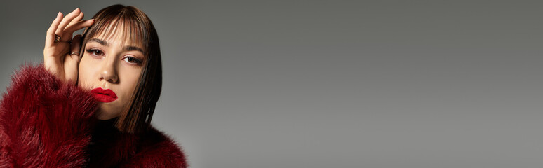 Young woman showcases stylish fashion in a captivating pose on a plain backdrop