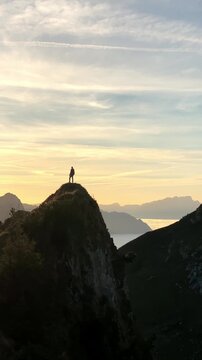 Man on top of a peak at sunset on the Stoos ridge hike with a stepped path in the foreground and a breathtaking sea of fog in beautiful autumn time