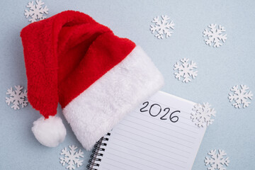 New Year 2026 planning. Santa hat, notebook, and snowflakes for resolutions and goals
