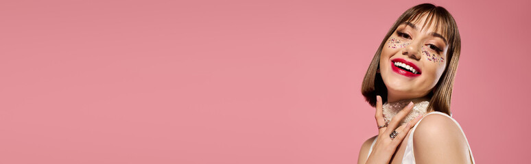 Young woman in trendy outfit expressing joy against a vibrant pink background
