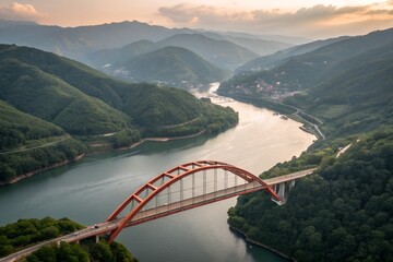 Red arch bridge over winding river in mountain valley