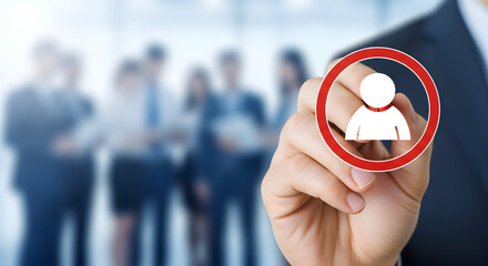 Hand draws a human icon inside a red circle on glass with a blurred office team in the background representing recruitment human resources talent acquisition and employee selection process