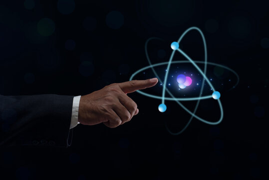 Businessman hand holding creative atom on blue background. Nuclear fusion concept, endless energy, cheap electricity, future technologies. Science and future concept - Powered by Adobe