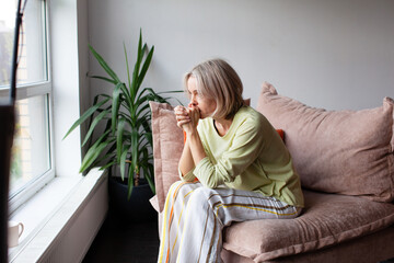 Sad Worried middle age woman sitting on Couch at home