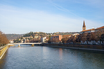 View of the city of Verona in Italy, across the Adige River On the left and right you can see the embankments, on the right side you can see Holmes part of the city. The sky is blue and clear