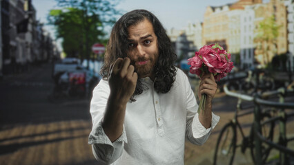 Fototapeta premium Man holds bouquet and makes beckoning gesture on a city street by parked bicycles; romance plea invitation.