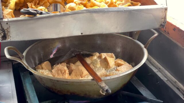Frying batagor (fried tofu meatball) video in hot oil in a wok.