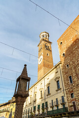 Obraz premium A tall rectangular tower in Verona, Italy The tower is made of red brick Part of the courtyard is visible below