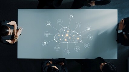 A business team collaborates at a sleek conference table, exploring cloud technology with digital icons. This visual captures innovation, connectivity, and teamwork in a modern workspace. Raster