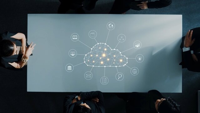 A business team collaborates at a sleek conference table, exploring cloud technology with digital icons. This visual captures innovation, connectivity, and teamwork in a modern workspace. Raster - Powered by Adobe