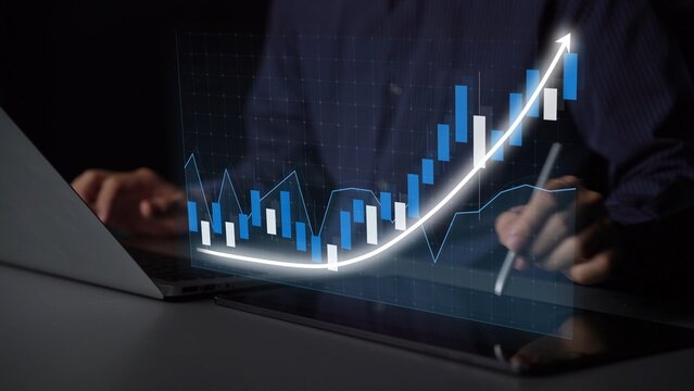 This image depicts a business professional analyzing a digital graph on a laptop, illustrating growth trends in finance and strategy, set in a modern workspace. Copula - Powered by Adobe
