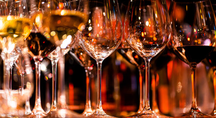 Elegant scene of wine being poured into glasses aligned in a row, showcasing the rich colors and...