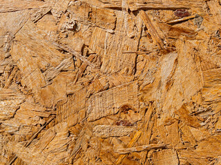 Close-up of natural osb wood surface showing rough texture and sunlight highlights