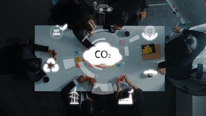 A diverse team of professionals collaborates in a modern office, discussing sustainable practices and strategies for achieving carbon neutrality in business initiatives. Raster