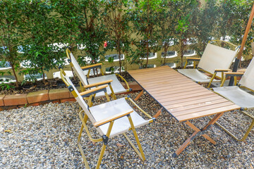 Colorful folding camping chair,wooden and chair set in garden on a sunny day,outdoor seating for restaurant or cafe.