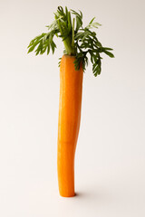 Peeled carrot with sprout standing upright on white background, fresh and healthy, perfect for food, nutrition, organic, and vegetable imagery