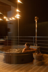 Relaxing evening in a hot tub on a balcony at night