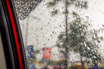 View from the inside of a working car,Car traffic jam,illuminated road during heavy rain and thunderstorms,highways in big cities,Rain drops on the car glass.