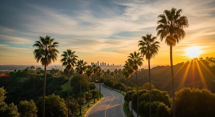 Obraz premium Golden hour illuminates a winding road lined with palm trees leading to the captivating Los Angeles skyline, inviting travel and adventure