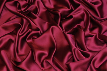 Obraz premium Close-up of soft, flowing maroon fuchsia Charmeuse satin texture. Ideal luxurious background for high-end fashion, beauty, or celebration themes.